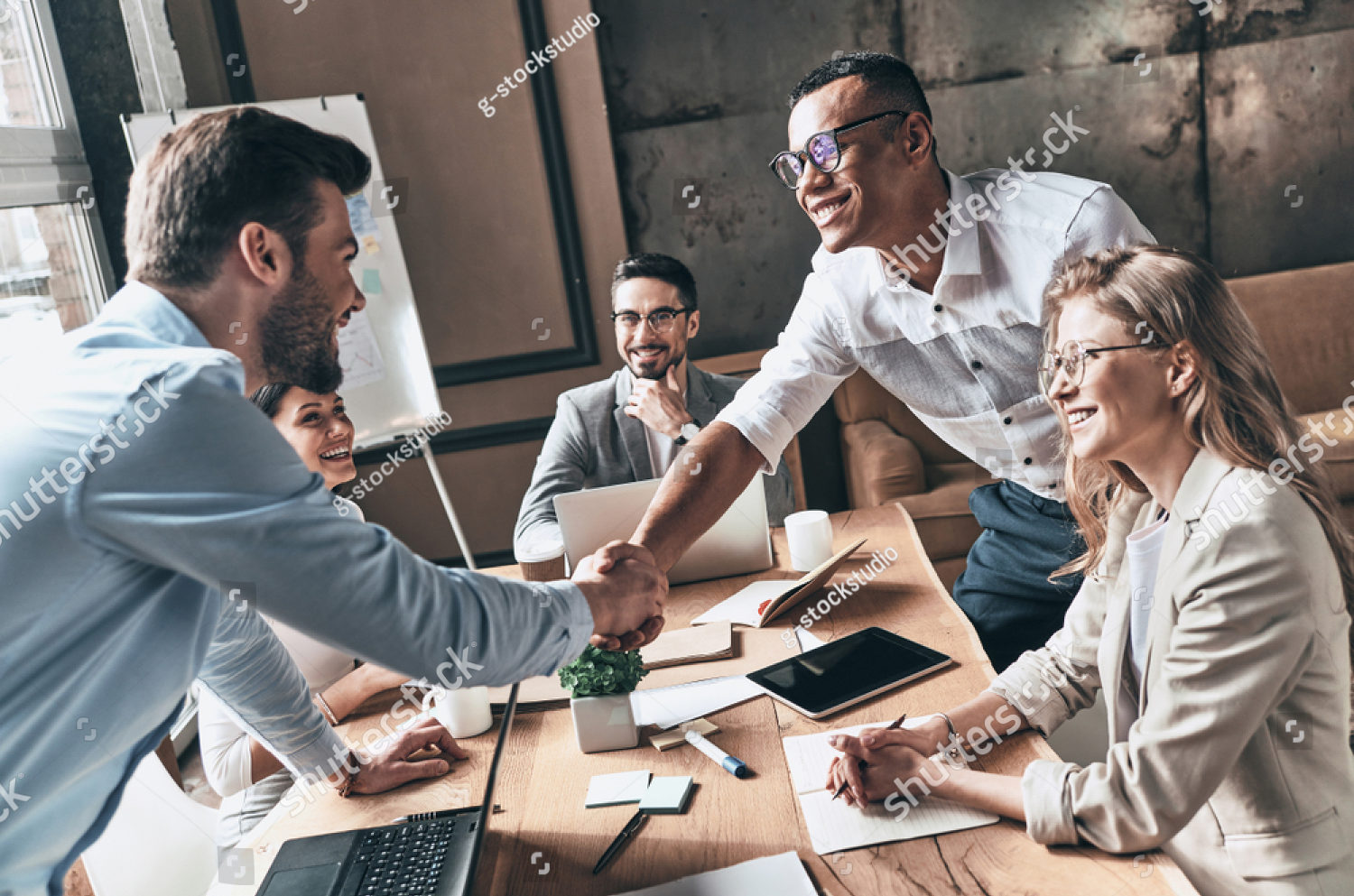 stock-photo-welcome-to-our-team-top-view-of-young-modern-men-in-smart-casual-wear-shaking-hands-while-working-1067103281